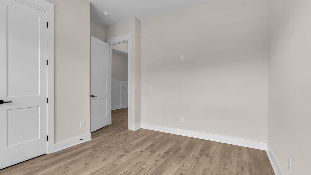 Secondary Bedroom with wood flooring (Representative of completed home)