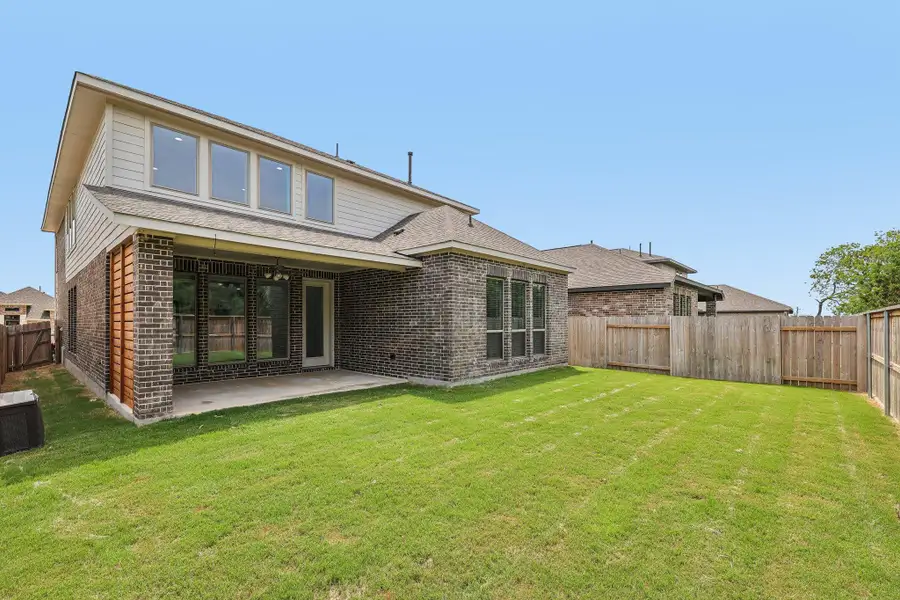 Rear view of house with brick siding, a patio, and roof with shingles Rear view of house with brick siding, a patio, and roof with shingles