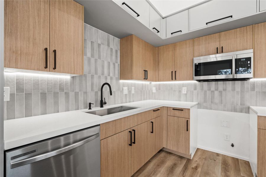 Clean, stylish kitchen details with quartz counters, matte black fixtures, and plenty of storage.