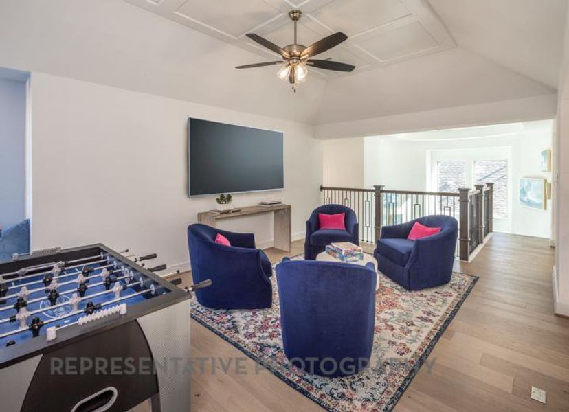 Living room with baseboards, wood finished floors, ceiling fan, and vaulted ceiling Living room with baseboards, wood finished floors, ceiling fan, and vaulted ceiling