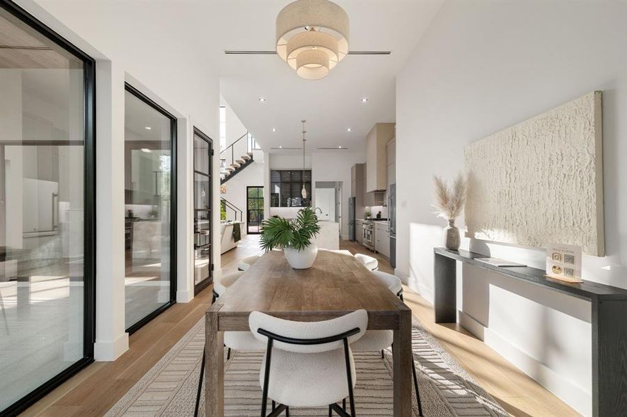 Spacious dining area featuring wood-finish flooring, a tiered chandelier, and recessed lighting
