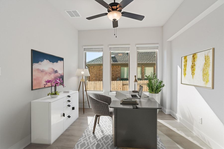 Home office with light wood-style flooring and a ceiling fan