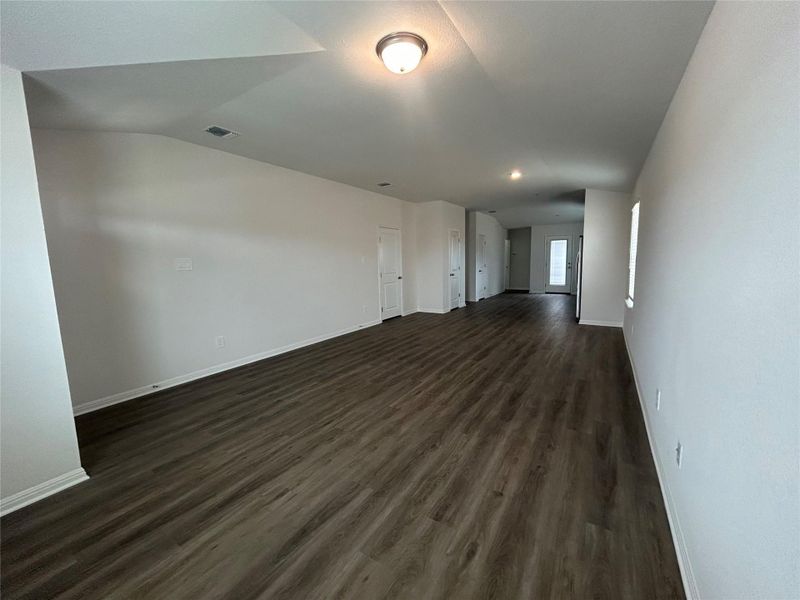 Empty room with dark wood-style floors and baseboards