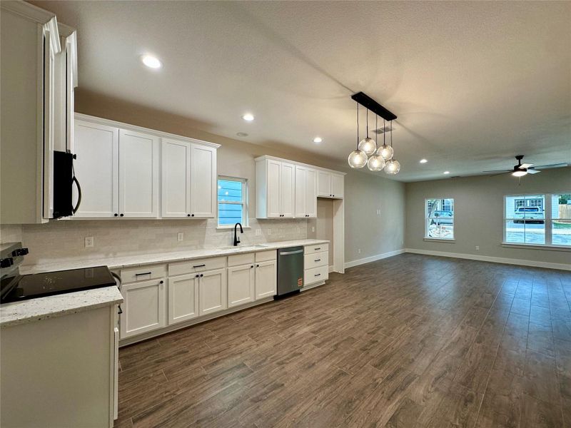 Kitchen featuring recessed lighting, white cabinets, range with electric stovetop, decorative backsplash, and dark wood finished floors