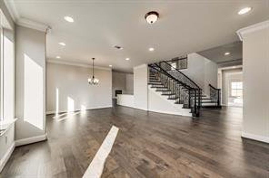 Unfurnished living room with dark hardwood / wood-style floors and ornamental molding