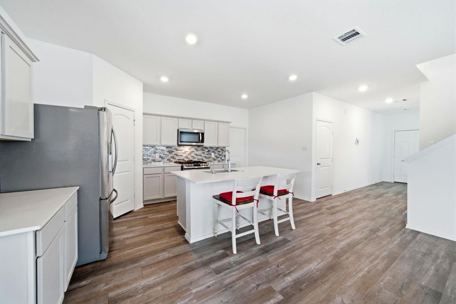 Modern kitchen with durable quartz surfaces, abundant cabinetry, and a cozy coffee station, neutral tones that pair with any décor.