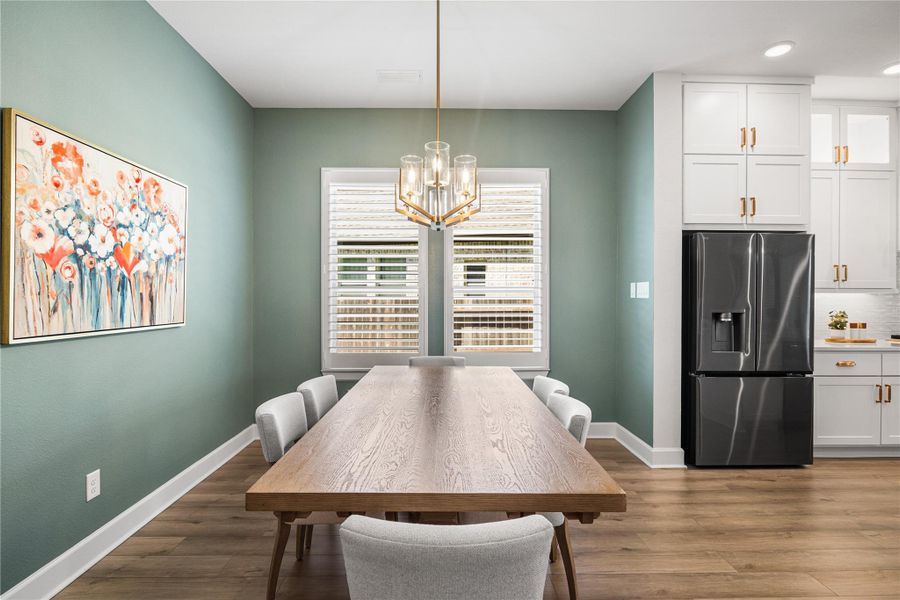 Dining area with updated light fixture and plantation shutters.