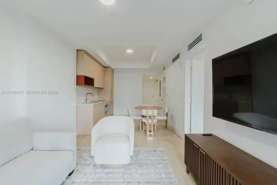 Light-toned wood-finish flooring, recessed lighting, and kitchen featuring flat-panel cabinetry with contrasting shelving Light-toned wood-finish flooring, recessed lighting, and kitchen featuring flat-panel cabinetry with contrasting shelving