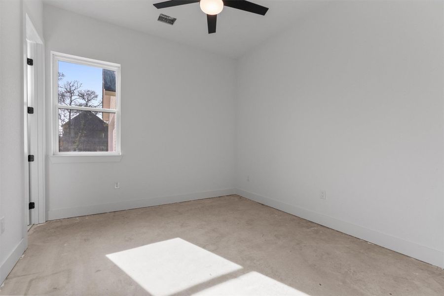 Empty room featuring unfinished concrete floors and a ceiling fan Empty room featuring unfinished concrete floors and a ceiling fan