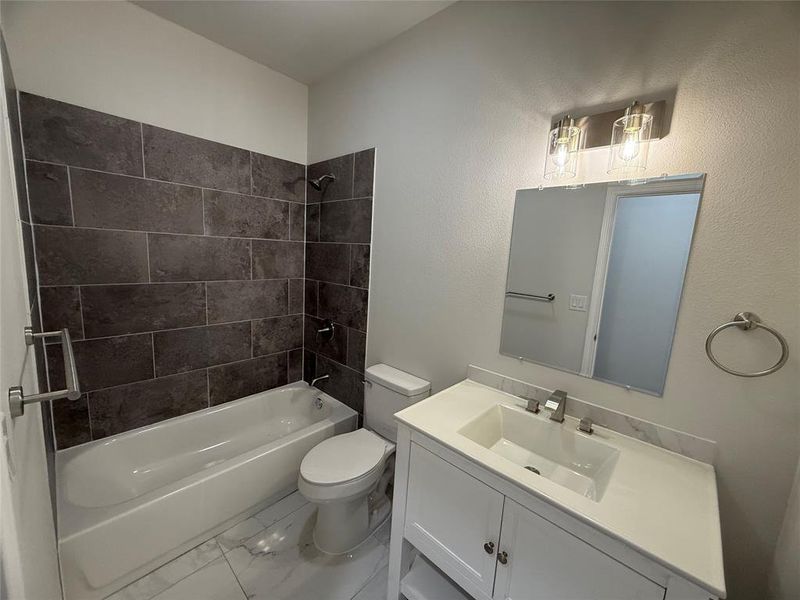 Full bathroom featuring vanity, toilet, and tiled shower / bath