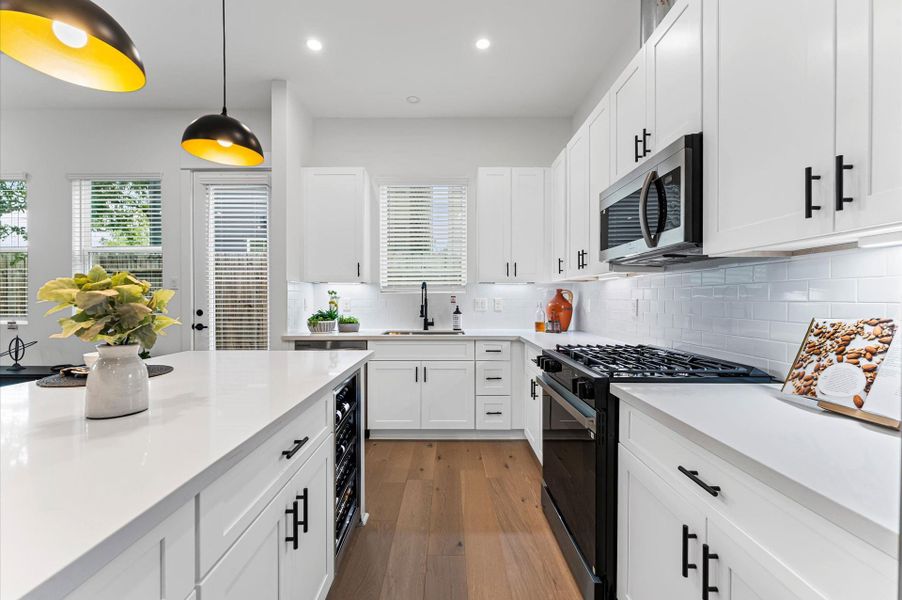 This stylish kitchen showcases plenty of sleek cabinetry, thoughtfully arranged to maximize storage and enhance the room’s modern aesthetic. Upper and lower cabinets feature clean lines and minimalist hardware, blending seamlessly with the space’s design. Integrated appliances and under-cabinet lighting add both function and flair, while the layout easy access and efficient organization. Ideal for culinary enthusiasts and entertainers alike, this kitchen combines smart storage with sophisticated style.
