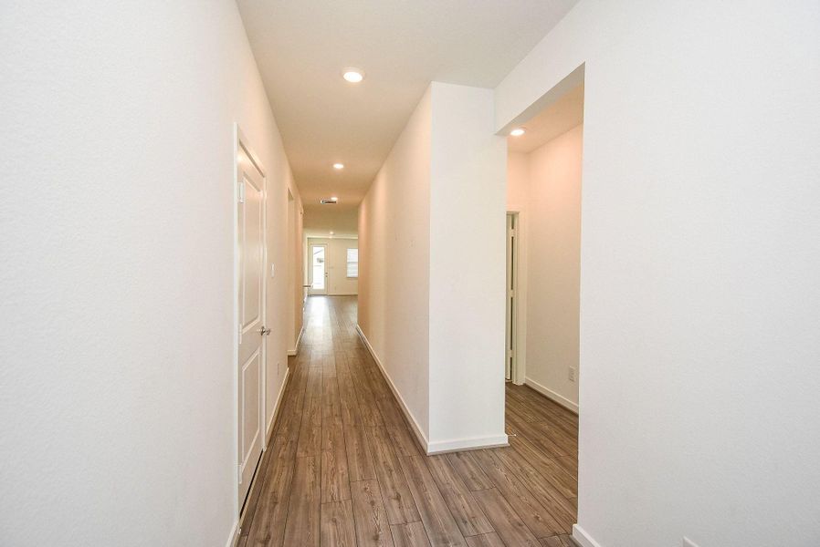 ENTRY HALLWAY LEADS TO SECONDARY BEDROOMS, GARAGE AND BATHROOMS