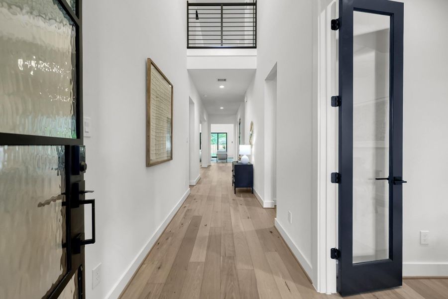 Bright entryway with wide hallway and wood flooring leading into the main living spaces. Bright entryway with wide hallway and wood flooring leading into the main living spaces.