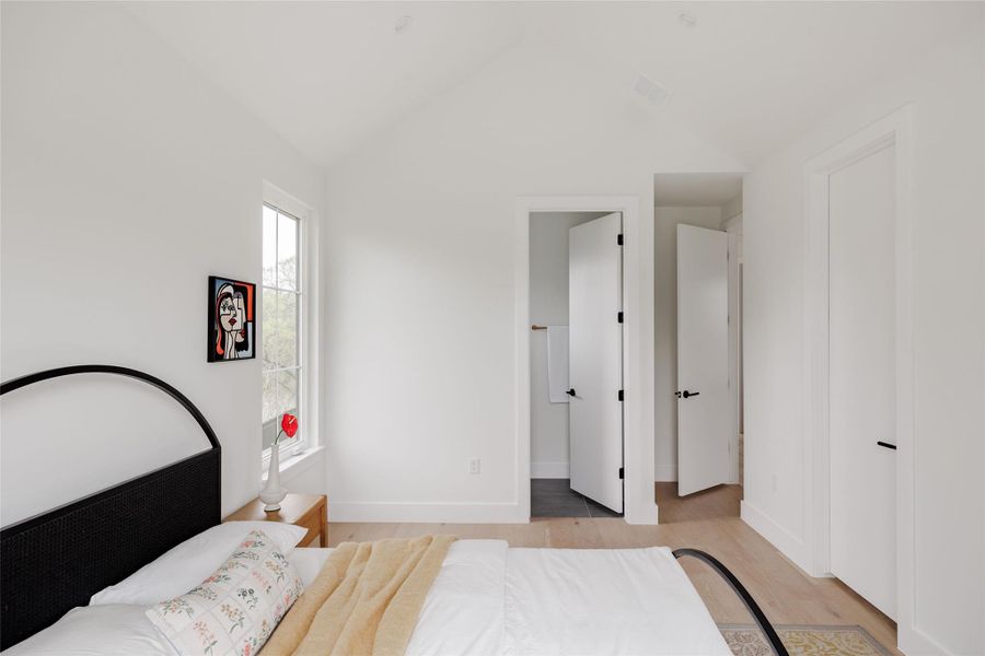 Bedroom with light wood finished floors and ensuite bath