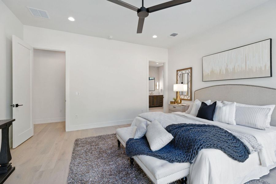 Bedroom with light wood-type flooring, recessed lighting, ensuite bath, and ceiling fan