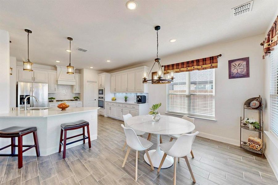 Dining space with wood tiled floors, a chandelier, and recessed lighting