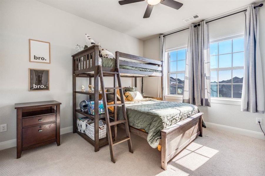 Bedroom with light carpet and a ceiling fan