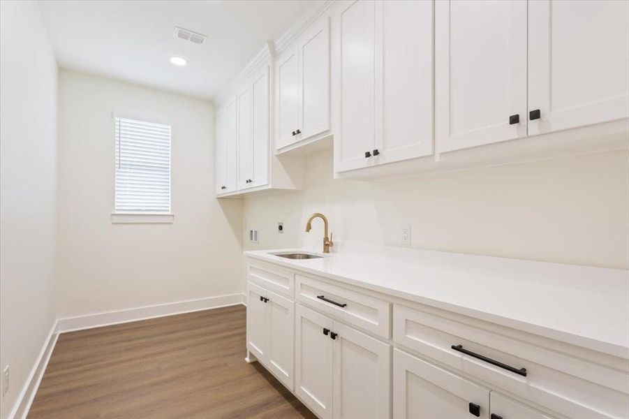 Laundry room featuring dark wood-style floors, cabinet space, recessed lighting, hookup for a washing machine, and electric dryer hookup