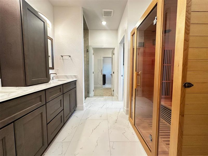 Full bath with marble finish floor, visible vents, a sink, a sauna, and a stall shower