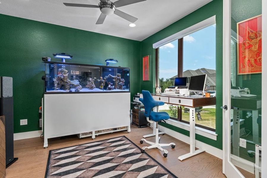 A dedicated home office provides a vibrant workspace, featuring rich green walls, a sizable window, and a sleek desk setup. A dedicated home office provides a vibrant workspace, featuring rich green walls, a sizable window, and a sleek desk setup.
