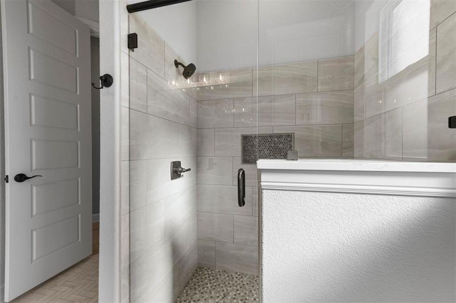 Bathroom featuring an enclosed shower and parquet flooring