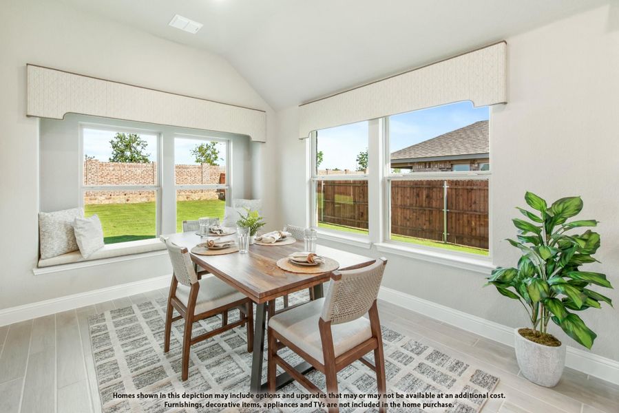 Bright dining area with wood table, built-in window seat, vaulted ceiling, and large windows overlooking backyard Bright dining area with wood table, built-in window seat, vaulted ceiling, and large windows overlooking backyard