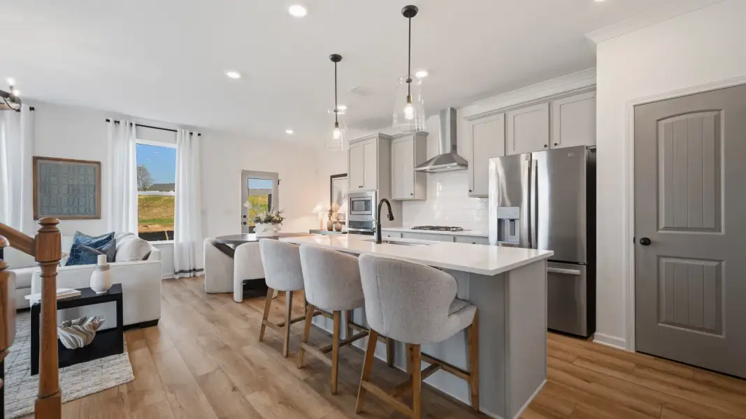 Bright open kitchen with quartz island and modern finishes in Langley Overlook townhome in Loganville, GA.