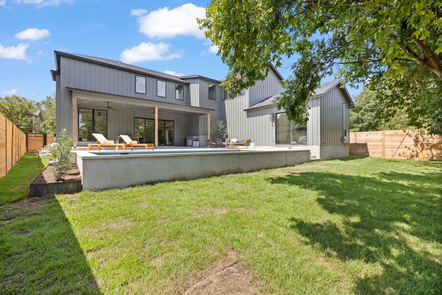 Back of property featuring a fenced backyard, a patio area, a ceiling fan, and board and batten siding Back of property featuring a fenced backyard, a patio area, a ceiling fan, and board and batten siding