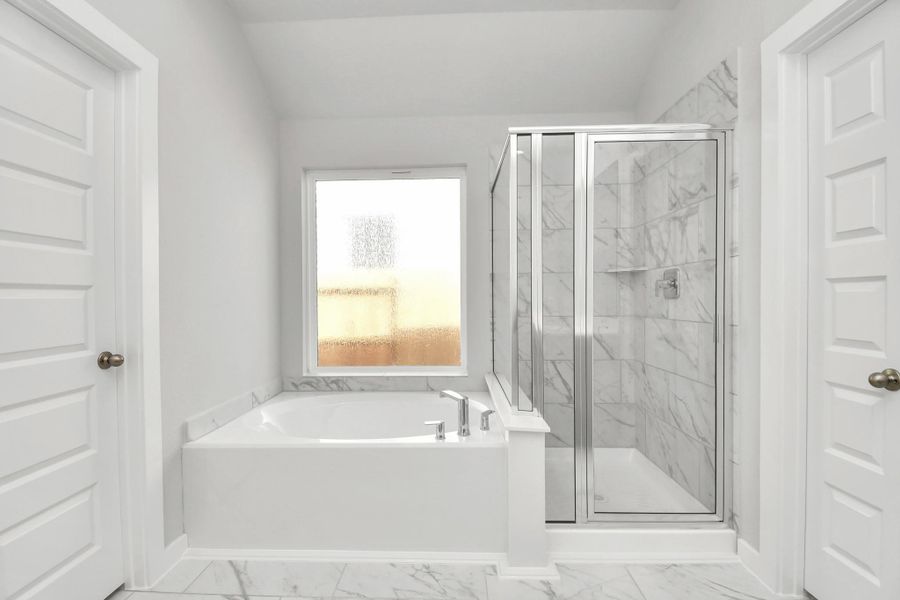 Escape to a spa-like oasis in this primary bathroom. Enjoy a walk-in showerwith tile surround, a separate garden tub with custom detailing, and an elegantvanity featuring light countertops, modern hardware, and beautiful recessed lights.Experience luxury and relaxation in every detail!
