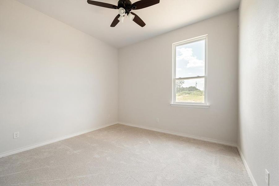 Carpeted spare room featuring ceiling fan