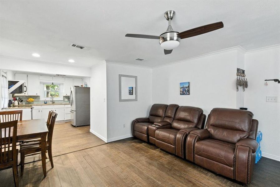 Living room with light wood finished floors, ceiling fan, ornamental molding, and recessed lighting Living room with light wood finished floors, ceiling fan, ornamental molding, and recessed lighting