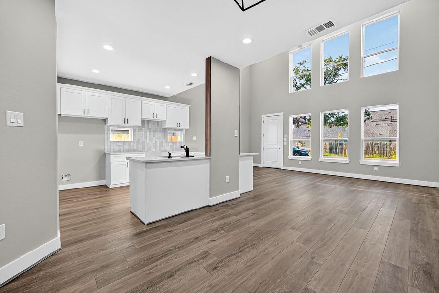 Here, air and light move freely—windows spanning two stories brighten the open layout, making it feel both connected and unconfined.