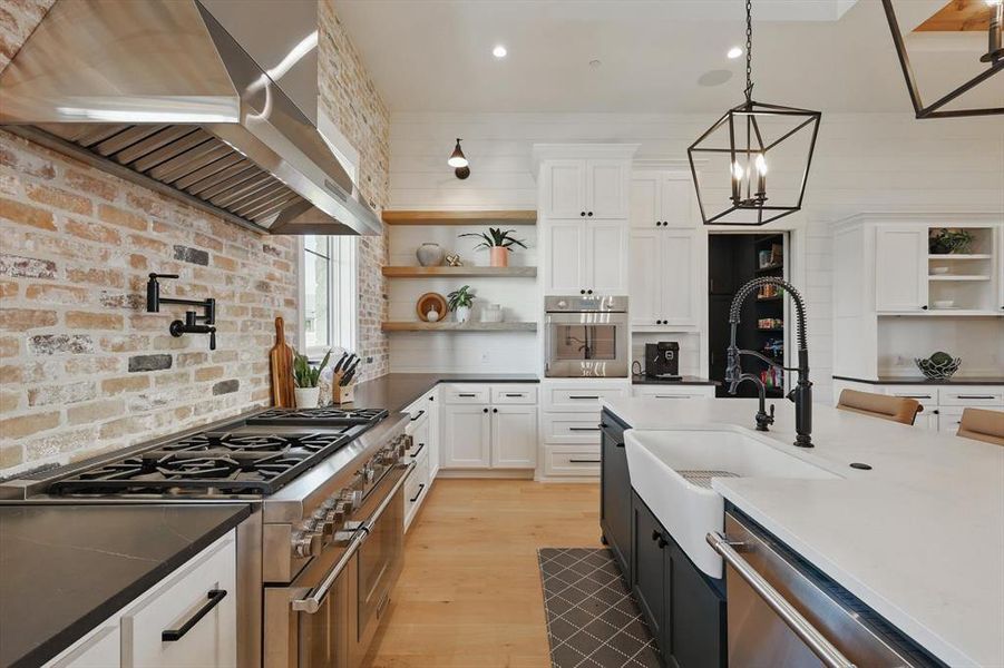 Kitchen featuring wall chimney exhaust hood, open shelves, stainless steel appliances, white cabinetry, and recessed lighting Kitchen featuring wall chimney exhaust hood, open shelves, stainless steel appliances, white cabinetry, and recessed lighting
