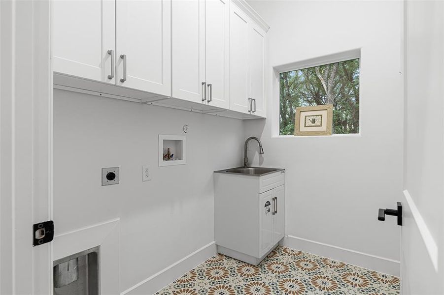 Laundry area featuring cabinets, hookup for an electric dryer, washer hookup, and sink