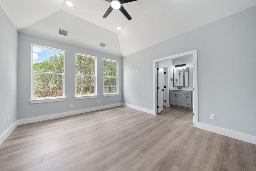 Spacious room featuring wood-finish flooring, vaulted ceiling, and recessed lighting
