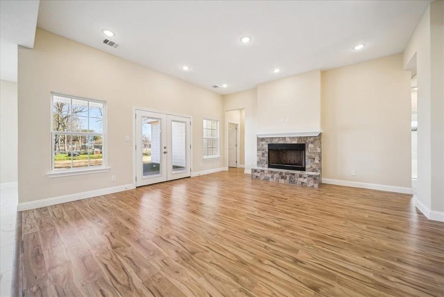 Unfurnished living room with a fireplace and light wood-type flooring