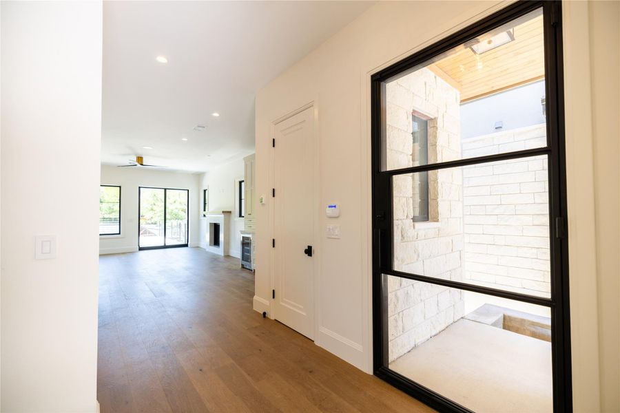 Hall with wood finished floors, recessed lighting, and baseboards