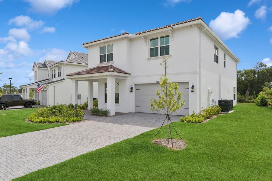 Front exterior of a new home in Salerno Reserve - Single Family, Stuart, FL, highlighting curb appeal (Image 1). Front exterior of a new home in Salerno Reserve - Single Family, Stuart, FL, highlighting curb appeal (Image 1).