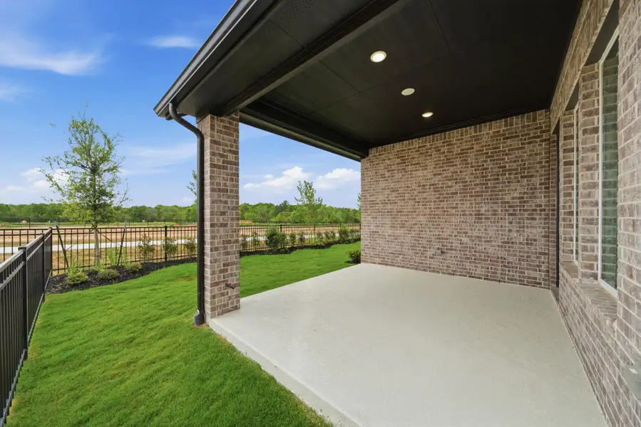 Covered back patio with ample space for outdoor dining and relaxation year-round.