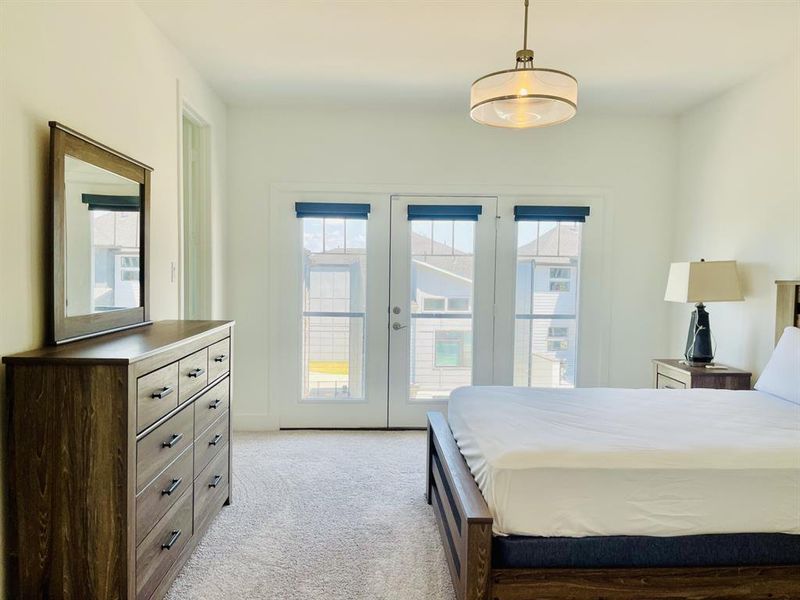 Bedroom featuring french doors, light carpet, and access to exterior Bedroom featuring french doors, light carpet, and access to exterior