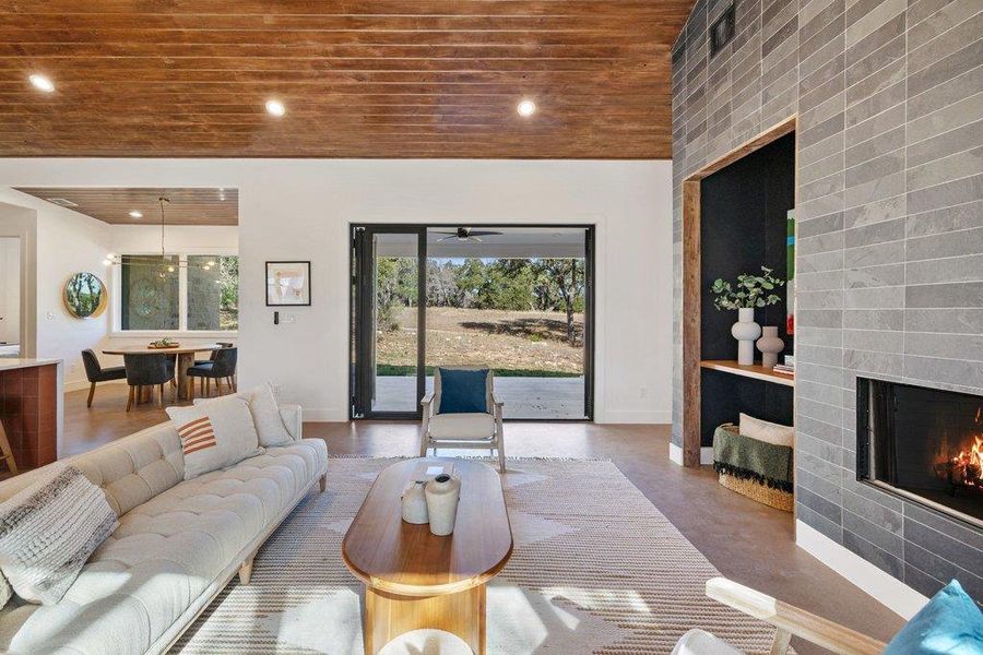 Living area featuring wooden ceiling, a fireplace, recessed lighting, and concrete flooring