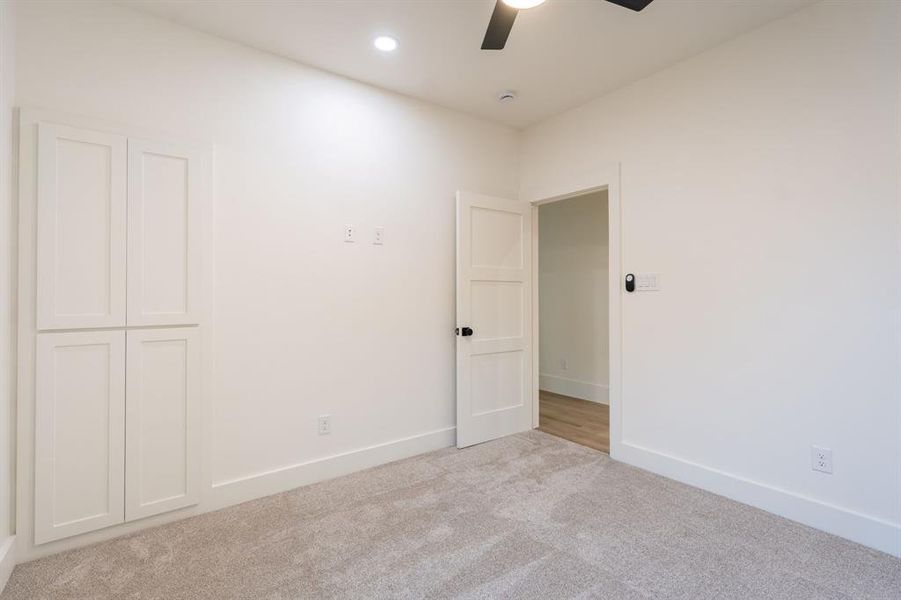 Unfurnished room featuring ceiling fan and light colored carpet