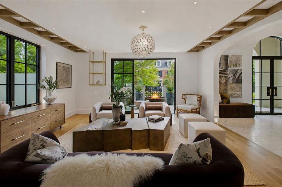 Custom ceiling treatment and lighting as architecture fill the room that spills out into the front courtyard