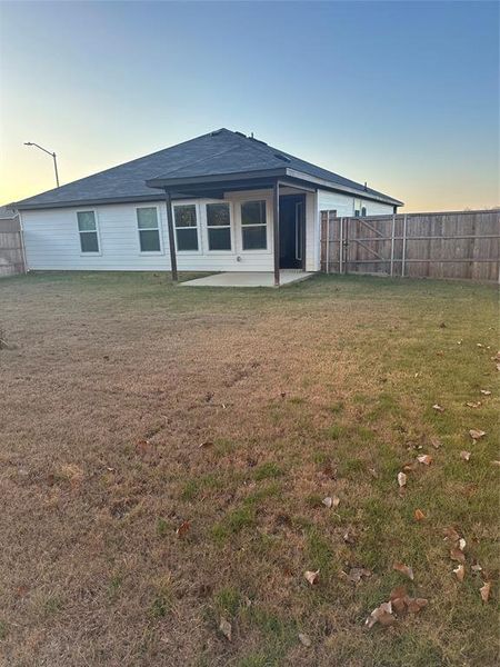Back of property at dusk featuring a patio and a fenced backyard