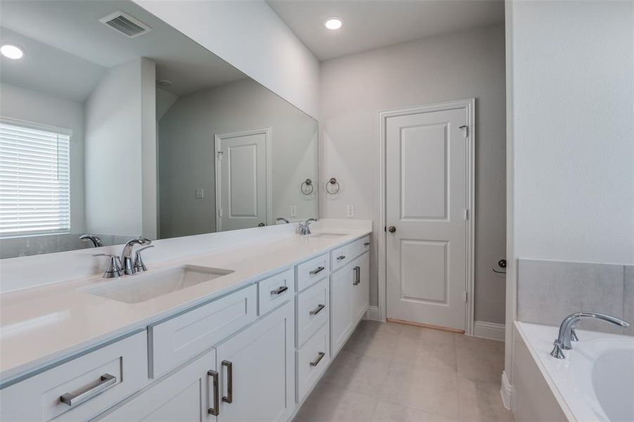 Dual vanity with white cabinetry and chrome hardware, featuring undermount sinks and a spacious countertop