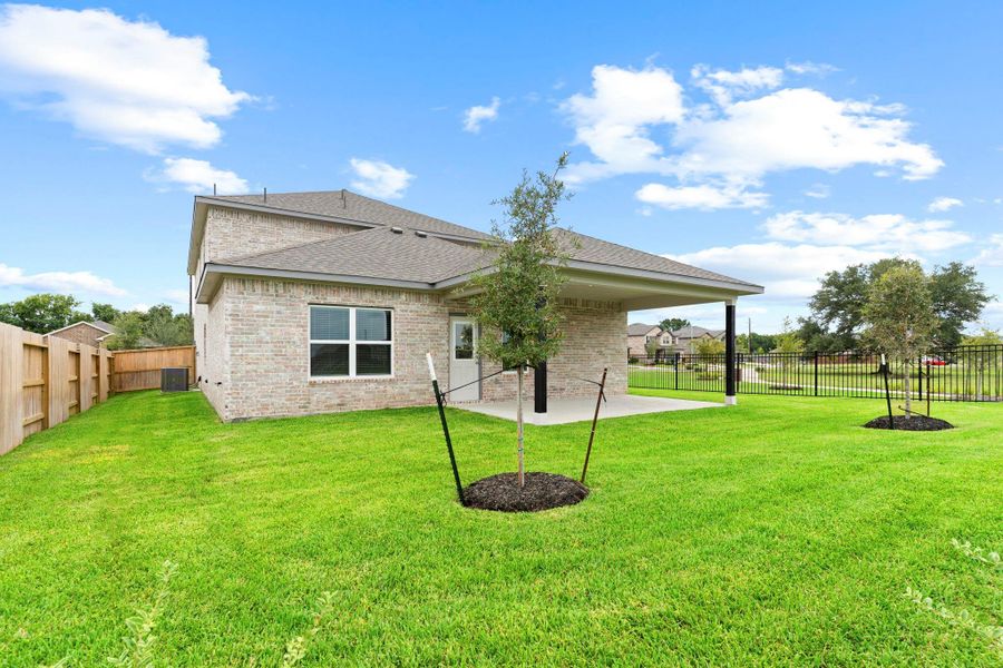 A rear view of the home showcases the full brick exterior, spacious yard, and pristine landscaping—perfect for play, pets, or future garden plans. Sprinkler system included. All Brick! A rear view of the home showcases the full brick exterior, spacious yard, and pristine landscaping—perfect for play, pets, or future garden plans. Sprinkler system included. All Brick!