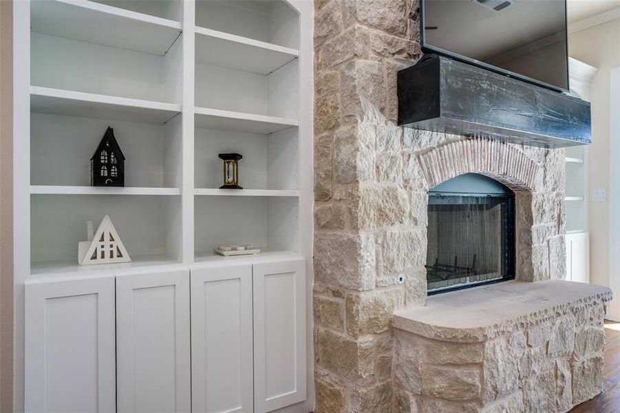 Room details with built in features and a stone fireplace