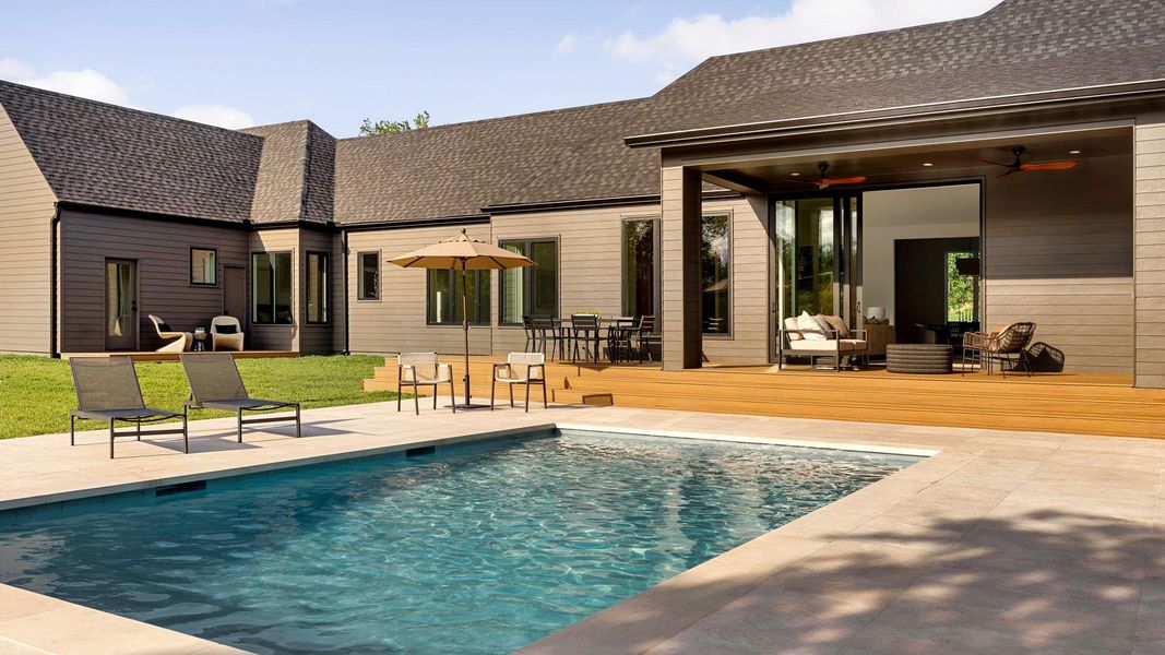 An inviting backyard oasis offers a sparkling pool and a spacious wooden deck for outdoor entertaining. An inviting backyard oasis offers a sparkling pool and a spacious wooden deck for outdoor entertaining.