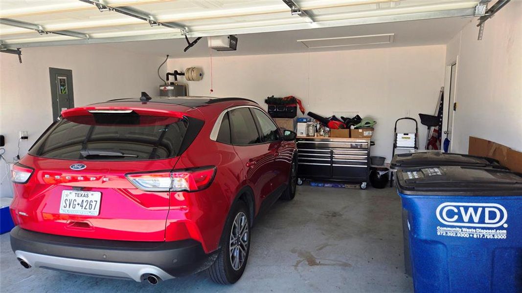 Two-car garage featuring a concrete floor, painted walls, and an overhead garage door