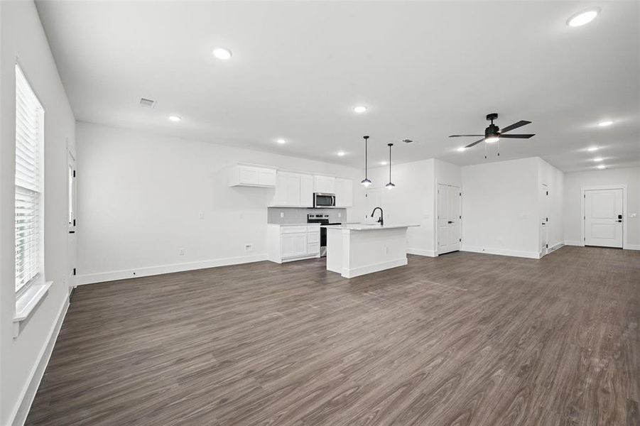 Unfurnished living room with recessed lighting, baseboards, dark wood finished floors, a sink, and ceiling fan Unfurnished living room with recessed lighting, baseboards, dark wood finished floors, a sink, and ceiling fan